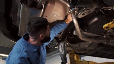 Garajdaki teknisyen aracı kontrol ediyor.