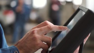 Tamirci araba servisinde tablet kullanıyor.