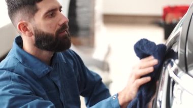 Otomobil servisinde cilalama aracı ile siyah araba cilası
