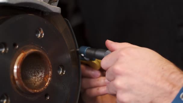Tukang reparasi fokus menggunakan alat untuk memeriksa chassis mobil — Stok Video