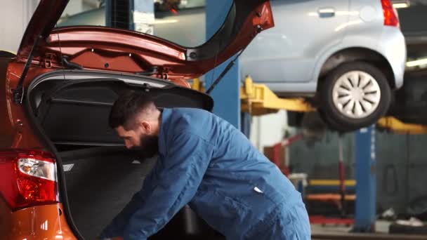 Mécanicien en unidorm voiture de contrôle dans le garage — Video