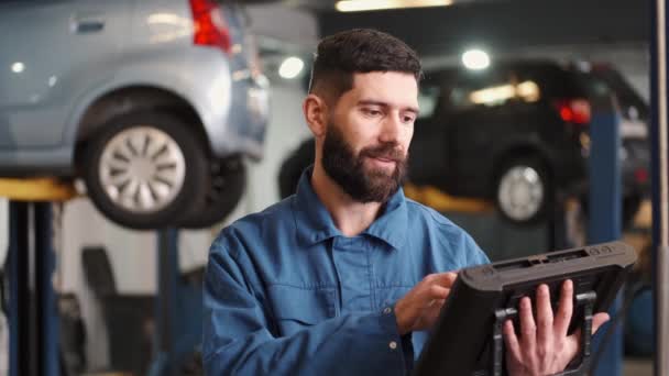 Mecánico utiliza una tableta en el servicio de coche — Vídeo de stock