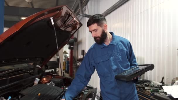 Profesional mecánico de automóviles examinar el motor del coche, mirando debajo de la capucha — Vídeo de stock