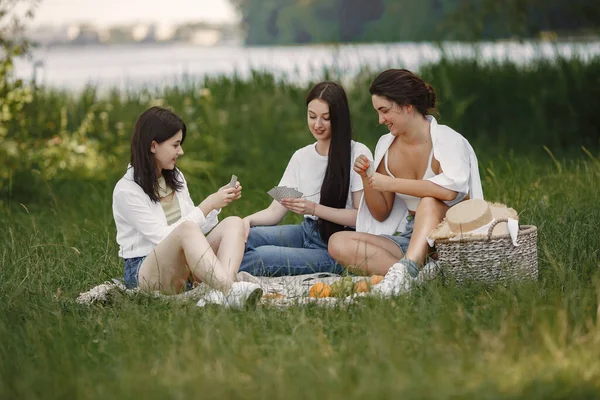 Group of girls play cards in a park — Stock Photo, Image