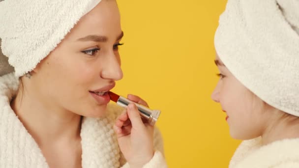 Мать и дочь в халатах делают макияж — стоковое видео