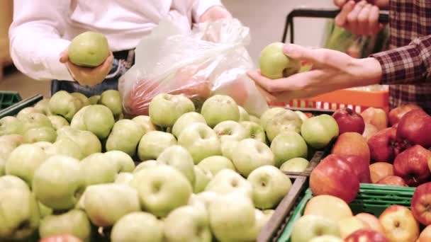 Jong stel koopt appels in supermarkt — Stockvideo