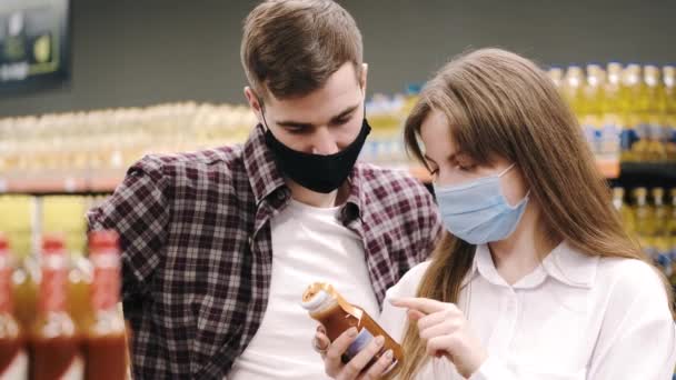 Couple dans des masques de protection faire du shopping au supermarché — Video