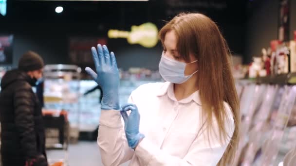 Γυναίκα με μάσκα με γάντια στο σούπερ μάρκετ — Αρχείο Βίντεο