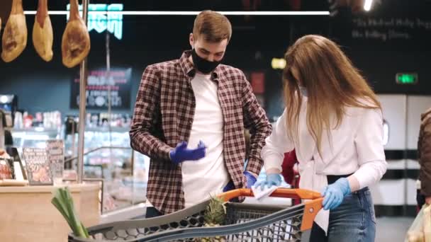 Pareja asa de limpieza del carrito de compras con toallita húmeda — Vídeos de Stock