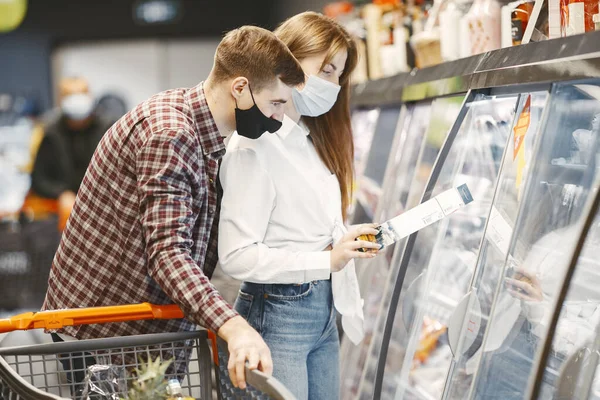 Persone con una maschera medica in un supermercato — Foto Stock