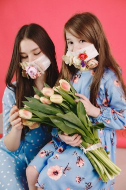 Kırmızı arka planda çiçekli maskeli kızlar