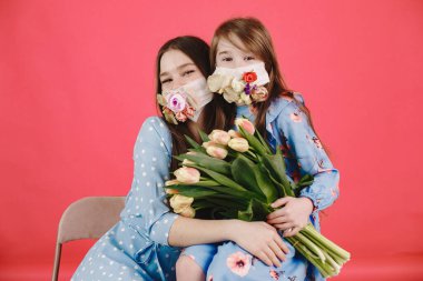 Kırmızı arka planda çiçekli maskeli kızlar