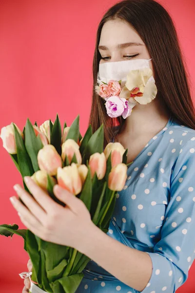 Chica en una máscara con flores sobre un fondo rojo — Foto de Stock