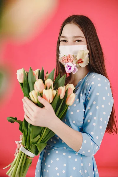 Gadis bertopeng dengan bunga di latar belakang merah — Stok Foto