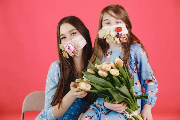 Kırmızı arka planda çiçekli maskeli kızlar
