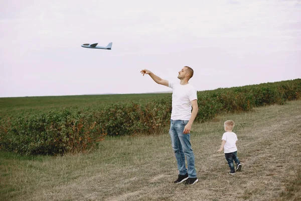 Father with little son playing with toy plane