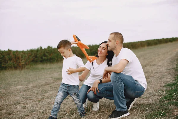 Aile bir tarlada yürüyor ve oyuncak uçakla oynuyor. — Stok fotoğraf