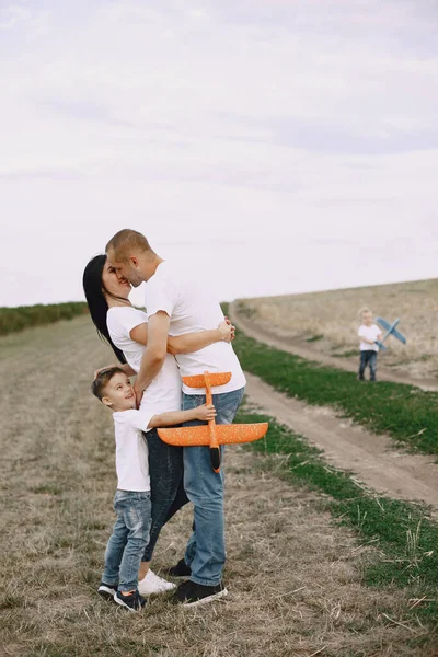Família caminha em um campo e brincando com avião de brinquedo — Fotografia de Stock