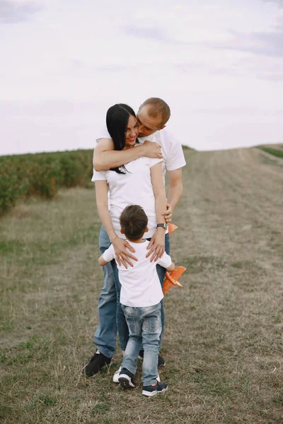 La famille marche dans un champ et joue avec un avion jouet — Photo