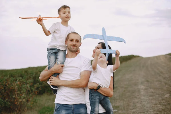 Aile bir tarlada yürüyor ve oyuncak uçakla oynuyor. — Stok fotoğraf
