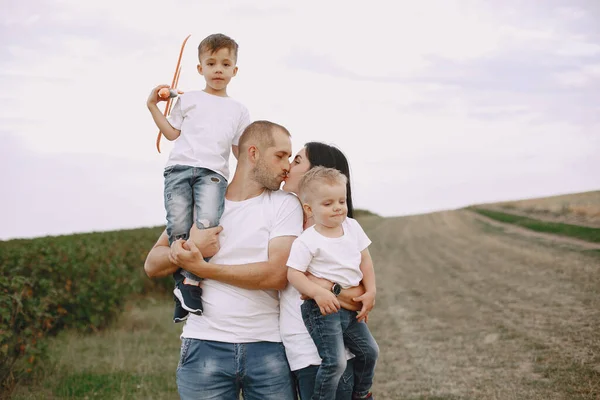 Rodzina spaceruje po polu i bawi się samolotem zabawki — Zdjęcie stockowe