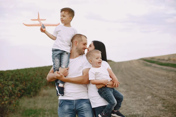 Aile bir tarlada yürüyor ve oyuncak uçakla oynuyor. — Stok fotoğraf