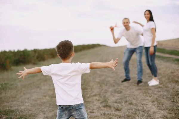 Familie spaziert auf Feld und spielt mit Spielzeugflugzeug — Stockfoto