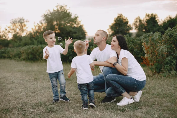 Söt familj som leker på ett sommarfält — Stockfoto