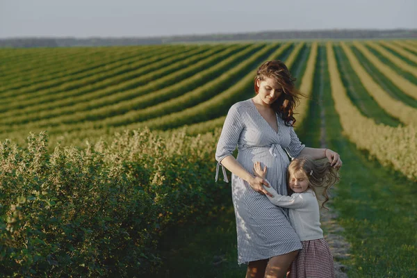 Mère enceinte avec sa fille dans un champ — Photo