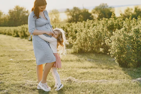 Mère enceinte avec sa fille dans un champ — Photo