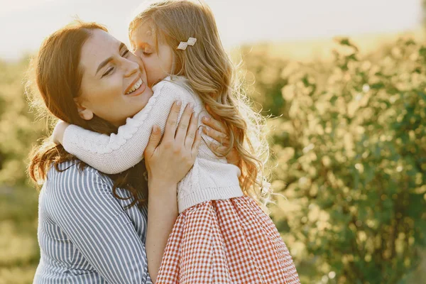 Zwangere moeder met haar dochter in een veld — Stockfoto