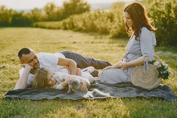 Familj med liten dotter tillbringar tid tillsammans i soligt fält — Stockfoto