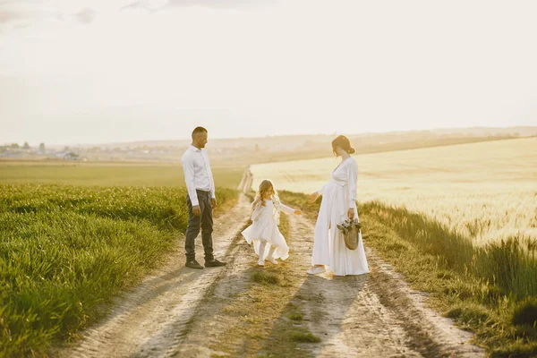 Famiglia con figlioletta trascorrere del tempo insieme in campo soleggiato — Foto Stock