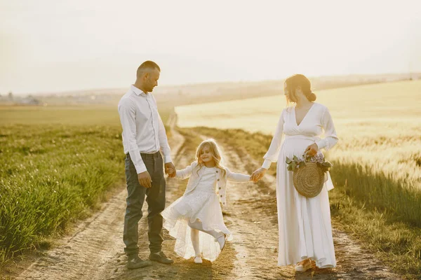 Familia con hija pequeña pasando tiempo juntos en el campo soleado —  Fotos de Stock