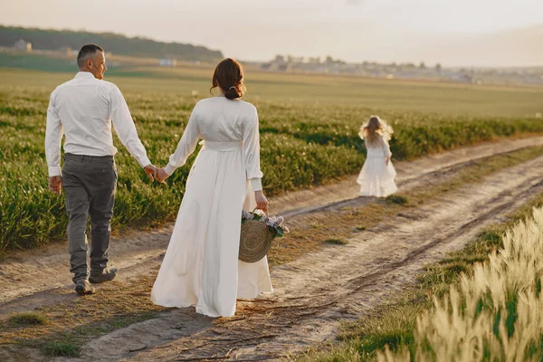 Familie mit kleiner Tochter verbringt Zeit zusammen auf sonnigem Feld — Stockfoto