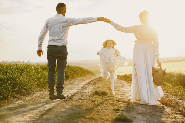 Família com filhinha passando tempo juntos no campo ensolarado — Fotografia de Stock