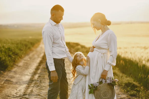 Família com filhinha passando tempo juntos no campo ensolarado — Fotografia de Stock