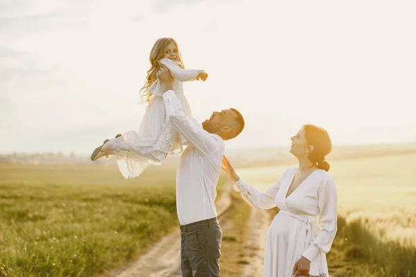 Rodzina z córeczką spędza czas razem na słonecznym polu — Zdjęcie stockowe