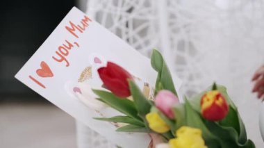 Laleli ve kartpostallı güzel bir kadın sandalyede oturuyor.