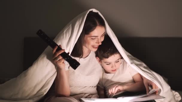 Mutter liest Märchen für Sohn unter der Decke — Stockvideo