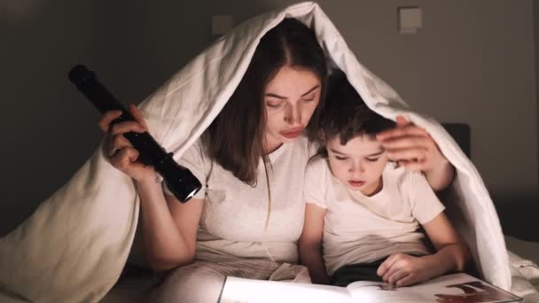 Mutter liest Märchen für Sohn unter der Decke — Stockvideo
