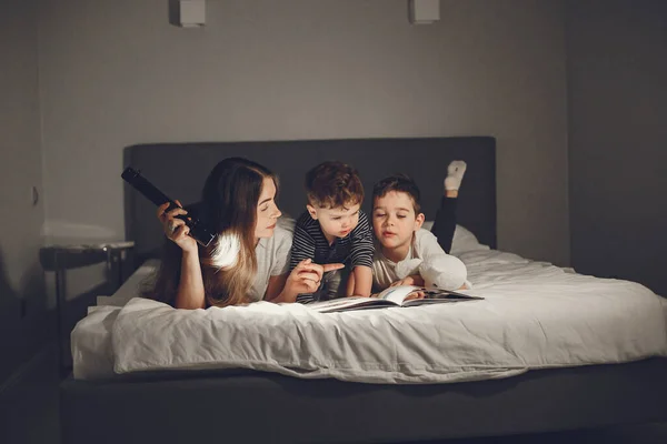 Mãe e criança lendo um livro com uma lanterna — Fotografia de Stock