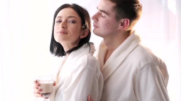 Молодой человек и женщина пьют коктейли в спальне — стоковое видео