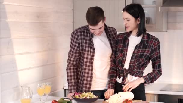 Молодая супружеская пара готовит дома — стоковое видео