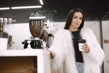 Kız tezgahta bir içki seçiyor.