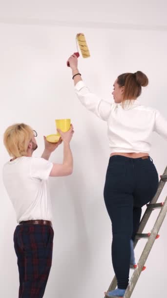 新しい家の中で一緒に若いカップルの絵画の壁 — ストック動画