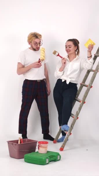 Felice giovane coppia pittura muro durante la ristrutturazione della casa — Video Stock
