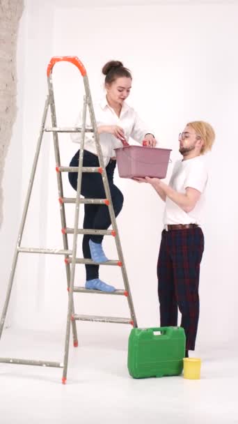 Młoda para maluje ściany razem w nowym domu — Wideo stockowe