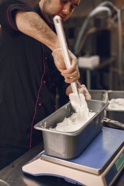 Erkek aşçı profesyonel mutfakta dondurma yapıyor.