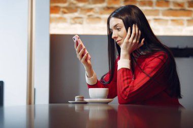 Sabahları restoranda kahve içen bir kadın.